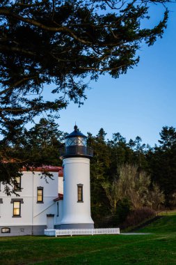 Whidbey Adası 'nda arkasında klasik Pasifik Kuzeybatı Ormanı olan Deniz Kuvvetleri Baş Feneri..