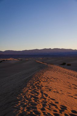 Gün doğumunda Ölüm Vadisi Ulusal Parkı 'ndaki kum tepelerinde ayak izleri..