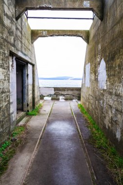 Eski bir kostüm topçu yerleşiminin terk edilmiş kalıntıları. Demiryolu rayları görüntüden izleyiciye gidiyor..