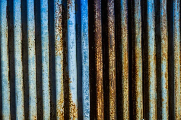 Rusted corrugated sheet metal siding background showing its age and weathering.