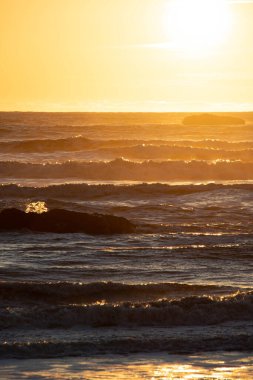 Güneş, Pasifik Okyanusu 'nun dalgalı denizlerinde Washington Eyaleti açıklarında batıyor..