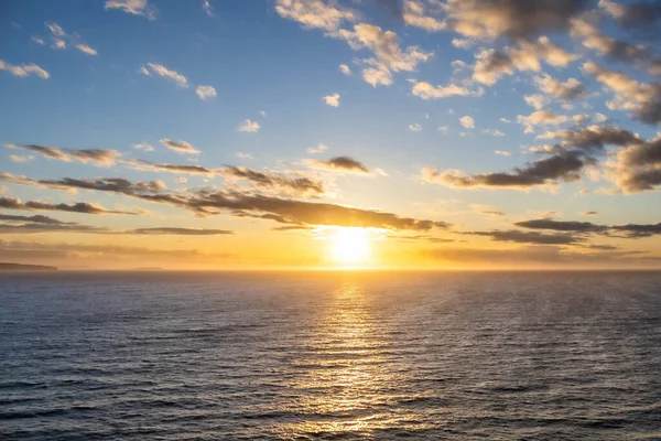 一个戏剧性的落日掠过海洋 五彩缤纷的天空和五彩缤纷的色彩在下面的波浪中反射出来 — 图库照片