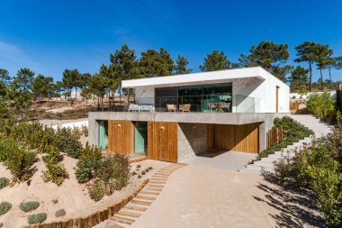 Bahçe havuzu ve ahşap güvertesi olan modern bir ev.