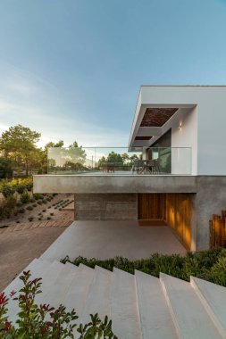 Bahçe havuzu ve ahşap güvertesi olan modern bir ev.