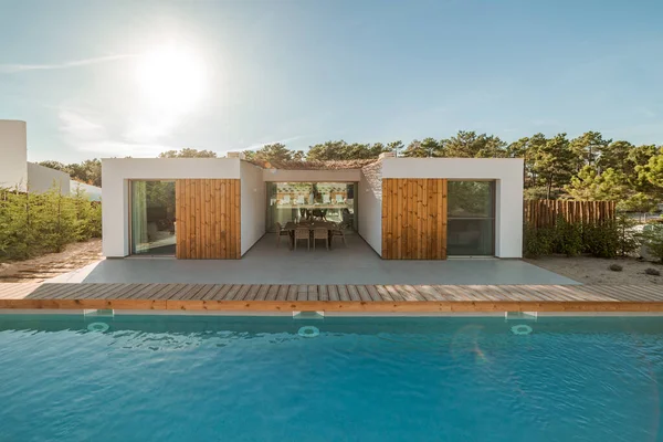 ガーデンスイミングプールと木製デッキ付きのモダンな家 — ストック写真