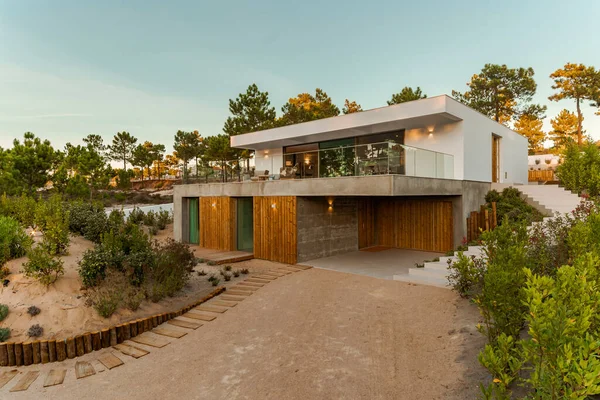 Bahçe havuzu ve ahşap güvertesi olan modern bir ev.