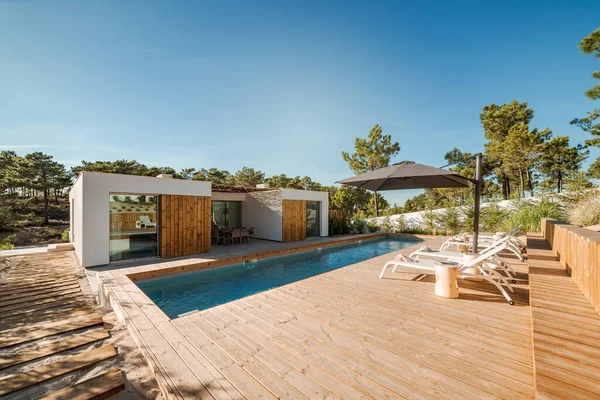 Modernes Haus Mit Garten Pool Und Holzdeck lizenzfreie Stockbilder