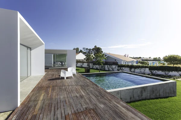 Casa moderna com piscina de jardim e deck de madeira — Fotografia de Stock