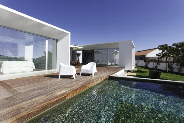 Bahçe havuzu ve ahşap güvertesi olan modern bir ev. — Stok fotoğraf