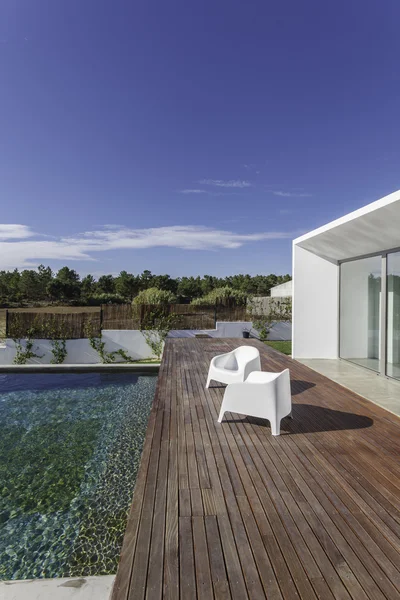 Casa moderna com piscina de jardim e deck de madeira — Fotografia de Stock