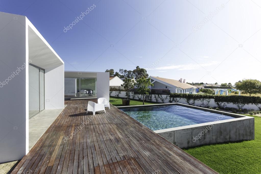 Modern house with garden swimming pool and wooden deck