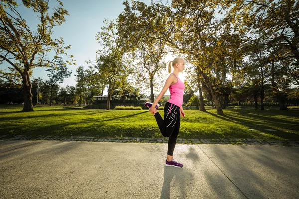 Mujer entrenando en parque urbano al atardecer —  Fotos de Stock