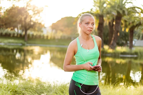 Frau mit Handy bereitet sich im Stadtpark auf Training vor — Stockfoto