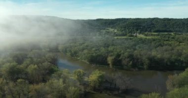 Wisconsin 'de Prairie du Chien yakınlarında bir sonbahar sabahı boyunca bulutlar ve sis bulutları Wisconsin Nehri boyunca tepeleri karartır.