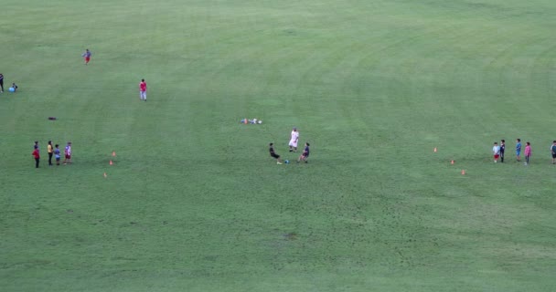 Crianças realizando uma broca de futebol em um campo em um parque público — Vídeo de Stock