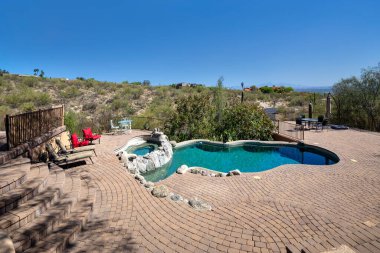 Çölde lüks bir evde yüzme havuzu ve teraslı bir bahçe..