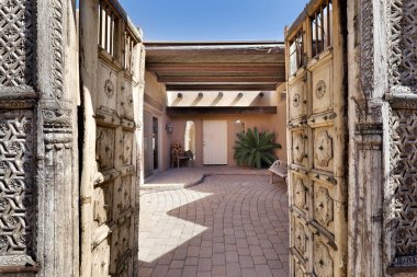 Lüks bir güneybatı evinde ahşap kapılarla döşenmiş duvarları ve tuğlaları olan bir avlu..