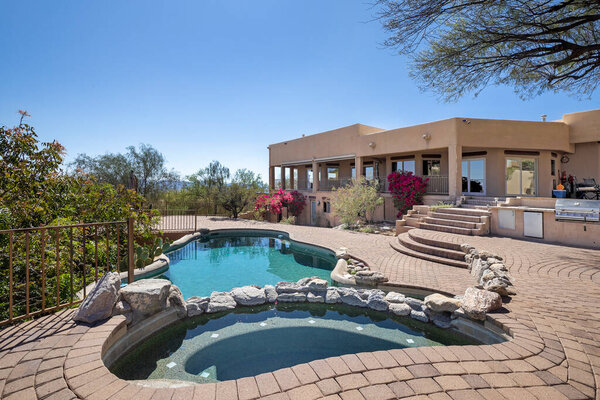 Swimming pool and terraced patio at a luxury home in a desert environment
