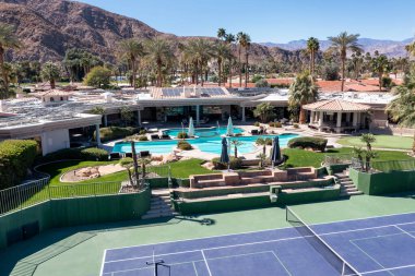 Yüzme havuzu ve lüks bir mahallede tenis / yankesicilik sahası olan büyük, lüks bir malikane manzarası..