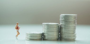 Para, Emeklilik ve Tasarruf kavramı. Yaşlı koşucu minyatür figür. İnsanlar para yığınına koşuyor..