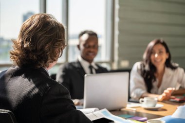 Çeşitlilik İş ve Çalışma paleti konsepti. İş kadını ve takım arkadaşıyla iş yerinde dizüstü bilgisayar, defter, akıllı telefon, tablet ve bir fincan sıcak kahveyle yapılan görüşmenin fotoğrafı..