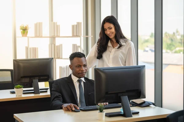 Diversity Business and Team Work concept. Young African businessman with smart businesswoman working  with desktop computer in office.