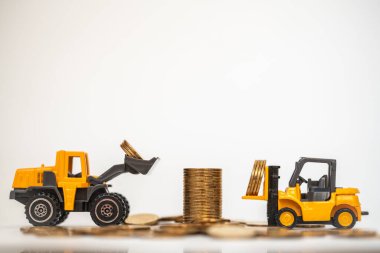İş, Para ve Finansal Konsept. Kapalı mini forklift ve yükleyici kamyonet oyuncak model beyaz arka planda altın sikkeler yığmak için madeni paralar içerir.