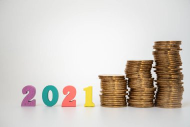 2021 Para, İş ve Planlama Konsepti. Beyaz arkaplanda dengesiz altın yığını olan renkli ahşap harf.