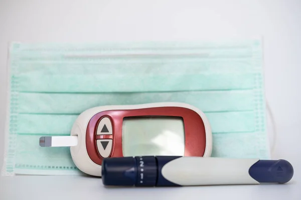 Lancet 수술용 마스크를 배경으로 Glucose Meter 클로즈업 당뇨병 저혈당증 그리고 — 스톡 사진
