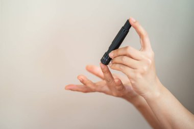 Kan şekeri seviyesini Glikoz ölçer ile ölçmek için kadın ellerini parmak üzerinde mızrak kullanarak kapat. İlaç, diyabet, glisemi, sağlık hizmetleri ve insanların konsepti olarak kullan.