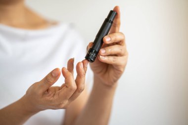 Kan şekeri seviyesini Glikoz ölçer ile ölçmek için kadın ellerini parmak üzerinde mızrak kullanarak kapat. İlaç, diyabet, glisemi, sağlık hizmetleri ve insanların konsepti olarak kullan.