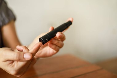 Kan şekeri seviyesini Glikoz ölçer ile ölçmek için kadın ellerini parmak üzerinde mızrak kullanarak kapat. İlaç, diyabet, glisemi, sağlık hizmetleri ve insanların konsepti olarak kullan.