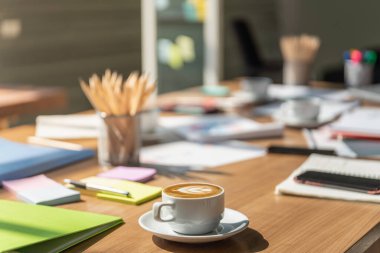 Süt köpüklü sütlü sütlü sütlü sütlü sütlü sütlü sütlü sütlü kahvenin yakın plan dosyası, kalem, çizelge, akıllı telefon, kalem ve defter..