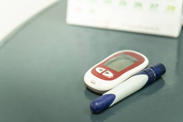 Nahaufnahme Eines Glukosemessers Mit Lanzette Und Kalender Als Hintergrund Einsatz — Stockfoto