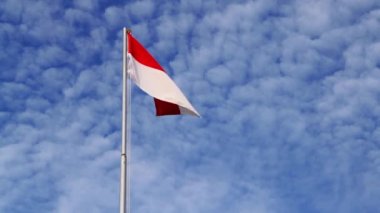 Endonezya Bayrağı açık havada dalgalanırken arkasında güzel mavi gökyüzü bayrak direğinde