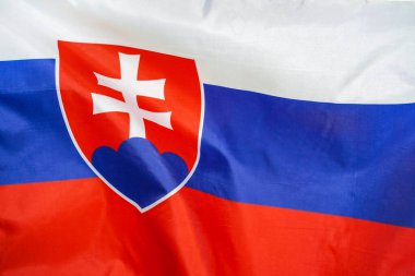 Slovakya 'nın kumaş desenli bayrağı. Slovakya bayrağı rüzgarda dalgalanıyor. Slovakya bayrağı birçok katlı bir spor kumaşı üzerinde tasvir edilir. Spor takımı afişi