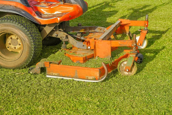 緑の芝生の背景に機械の芝刈り機 芝生のケア 乗馬用芝刈り機 — ストック写真