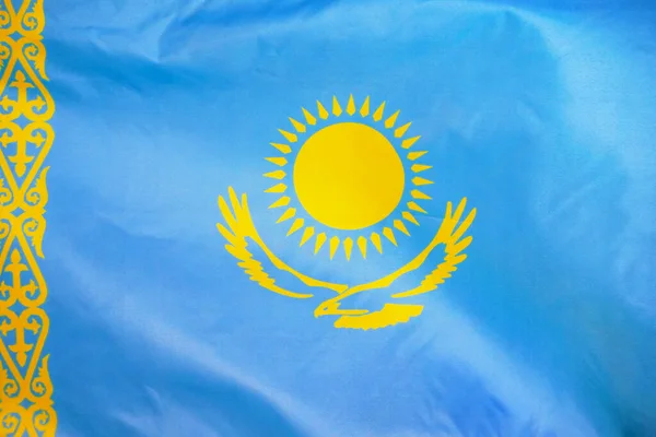 Fabric texture flag of Kazakhstan. Flag of Kazakhstan waving in the wind. Kazakhstan flag is depicted on a sports cloth fabric with many folds. Sport team banner