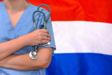 Hollanda bayrağının arka planında steteskopu elinde olan kadın cerrah ya da doktor. Hollanda 'da ameliyat konsepti