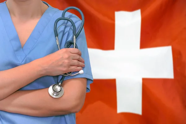 İsviçre bayrağının arka planında steteskopu olan kadın cerrah ya da doktor. İsviçre 'de ameliyat konsepti