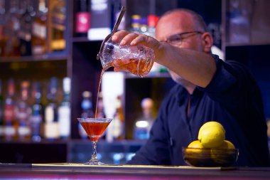 Barmen kokteyl yapar. Hizmet konsepti. Gece vakti..