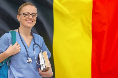 Steteskop ve Belçika bayrağı geçmişi ile ilgili kitapları olan bir bayan doktor. Tıp eğitimi konsepti. Belçika 'da tıp eğitimi