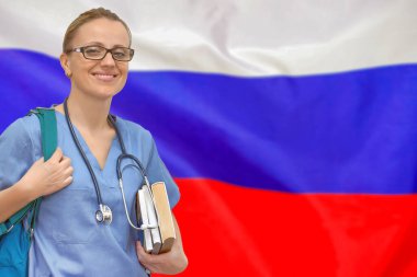 Steteskoplu ve elinde Rusya bayrağı ile ilgili kitaplar olan bir bayan doktor. Tıp eğitimi konsepti. Rusya 'da tıp eğitimi