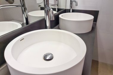 Modern beyaz lavabo musluklu. Lüks otellerde modern tasarımla banyo içi lavabo..