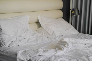 Otelde kırışık yatak. Bitmemiş ya da dağınık yatağın komik gecelerden sonraki yakın çekimi, yeni evli çiftin seksi. Otel odasında kirli yatak.