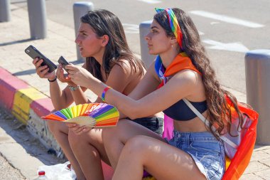 Geleneksel LGBT geçit töreni. Gay Onur Yürüyüşü 'ndeki iki kadının portresi. Hoşgörü geçidi. Gay onur yürüyüşünde gökkuşağı bayrakları. 14 Haziran 2019. Tel Aviv 'de. İsrail.