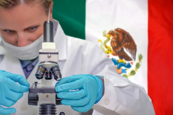 Biochemička Dívá Skrz Mikroskop Pozadí Mexické Vlajky Lékařská Technologie Farmaceutický — Stock fotografie
