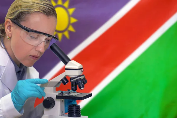 Kobiety Biochemik Mieszania Substancji Badania Pod Mikroskopem Tle Flagi Namibii — Zdjęcie stockowe