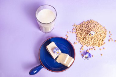 Soya fasulyesi ve soya sütü yerine vejetaryen vejetaryen minimalist fotokopi alanı negatif uzay pastel mor arka plan besin tarzı ilham kaynağı.