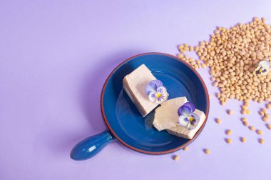 Soya fasulyesi ve soya sütü yerine vejetaryen vejetaryen minimalist fotokopi alanı negatif uzay pastel mor arka plan besin tarzı ilham kaynağı.